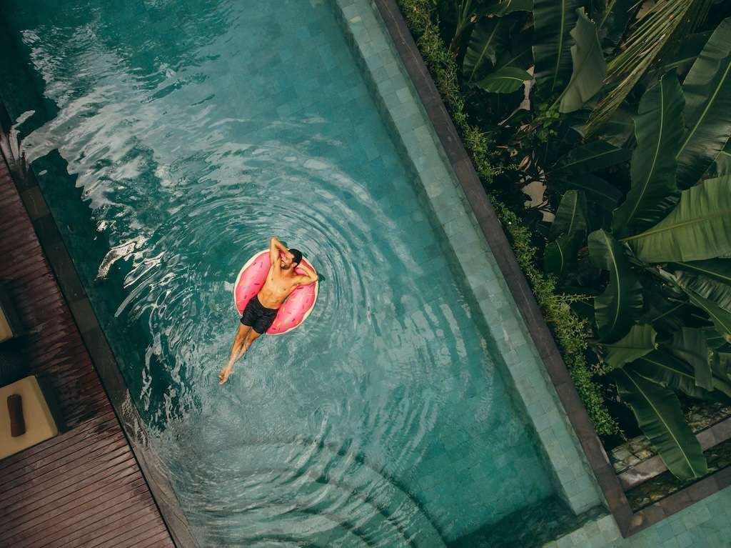 Traveller enjoying their time off in a pool in a donut floatie