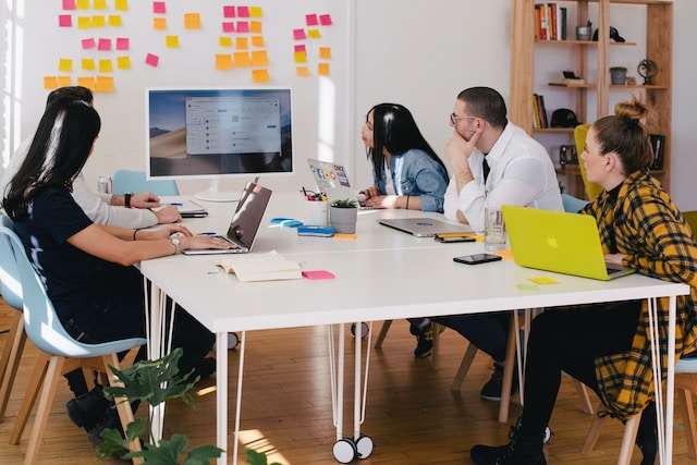 Coworkers conducting a SWOT analysis workshop with a whiteboard and post-its