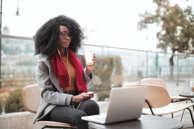 Woman sitting at her laptop with coffee in her hand