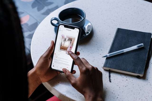 Frau an einem Tisch, die auf Instagram scrollt