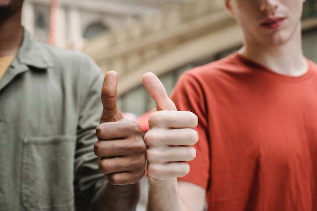 Two people giving a thumbs up 